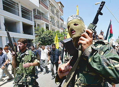 Armed Hamas militants marching in streets with civilian supporters.