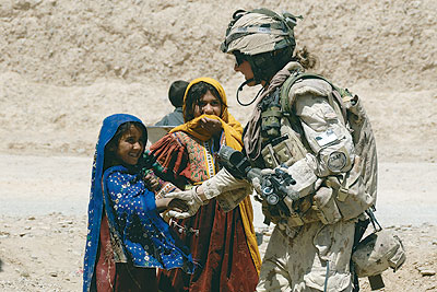 Canadien female soldier greets Afghani girls