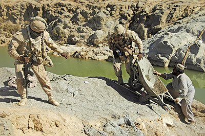 Force Protection Members help a local Afghan worker