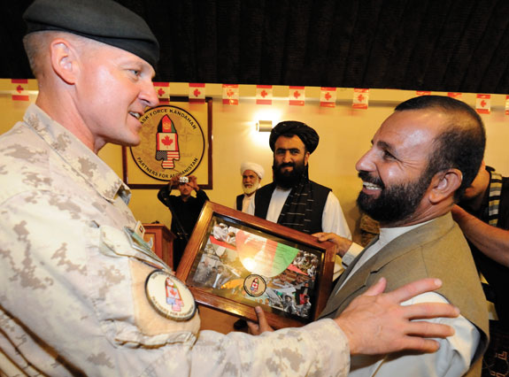 Commander TF Kandahar presents Daman District Leader with a gift following the Transfer of Command Authority Ceremony