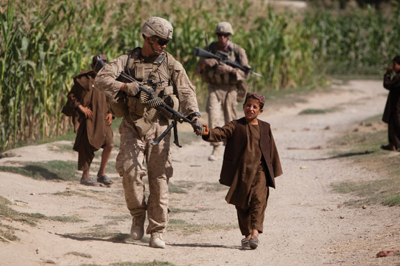 Soldier walking hand-in-hand with boy