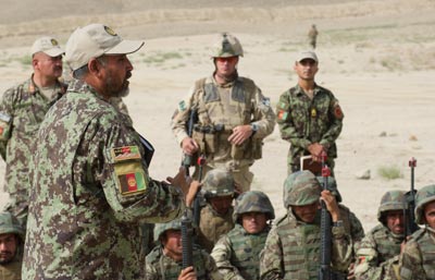 Des soldats afghans durant un exercice de contre-embuscade au Centre consolidé de mise en service de l’équipement de Kaboul. Un soldat de la Contribution du Canada à la mission de formation en Afghanistan, observe la scène