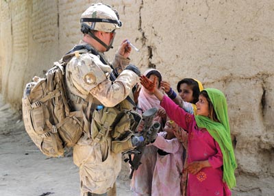 Royal 22e Régiment soldier is swarmed by local Afghan children during an early morning operation in Panjwa’i District to clear several small villages and compounds