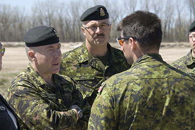 The Chief of the Land Staff, Lieutenant-General Peter Devlin (left) and Army Sergeant Major Chief Warrant Officer Giovanni Moretti speak with a soldier working at the Manitoba flood mitigation, 15 May 2011.