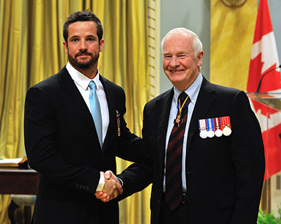 Specialist Graves is congratulated by the Governor General after receiving his Medal of Military Valour.