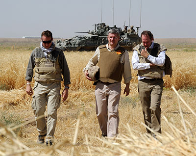 Canada’s Prime Minister, the Right Honourable Stephen Harper, the Canadian Minister of National Defence, the Honourable Peter MacKay, and Tim Martin, Canada’s Representative in Kandahar, walk through the wheat fields at Tarnack Farms near Kandahar City during a surprise visit, 30 May 2011.