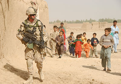 Private Paul Bennett, from the Second Battalion of the Royal Canadian Regiment, draws a following of interested children as he provides security for members of the Provincial Reconstruction Team.