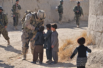 A soldier from Task Force Kandahar greets local Afghan children while on a foot patrol, 22 January 2011.