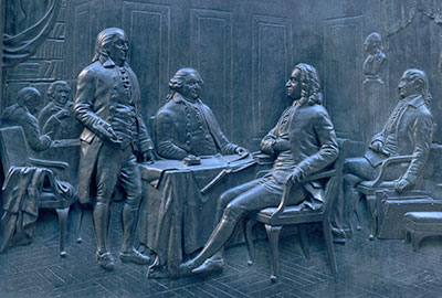 Relief sculpture of Benjamin Franklin signing the Treaty of Paris.