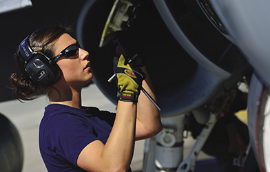 female avionics technician servicing a CF-18 Hornet)