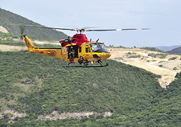 A Canadian Armed Forces CH-146 Griffon Search and Rescue helicopter manoeuvres through the hills during a training exercise near Kingston, Jamaica.