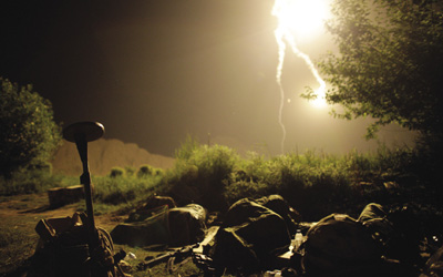 Canadian soldiers sleep as a flare burns over them during a special operation at Sanjaray in Kandahar Province, 18 May 2009.