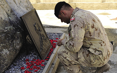 (Un sergent canadien rend hommage à des camarades morts au combat à Kaboul, en Afghanistan, le 11 novembre 2013.)