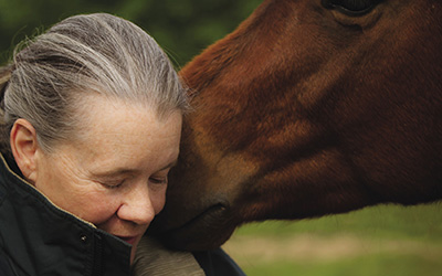(woman and horse in a tender moment)
