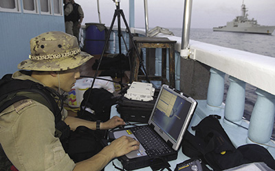Transmitting data to HMCS <em>Iriquois</em> after boarding a dhow suspected smuggling drug in Arabian Sea.