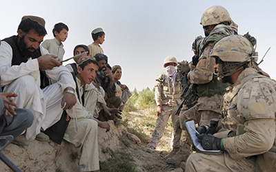 Members of The Royal Canadian Regiment Battle Group gather security information from Afghan villagers.