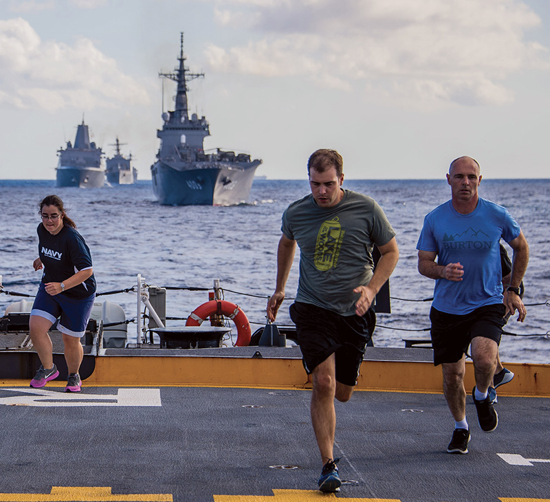 Service members exercising onboard ship.